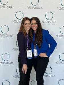This image shows two women together in front of a step and repeat backdrop.